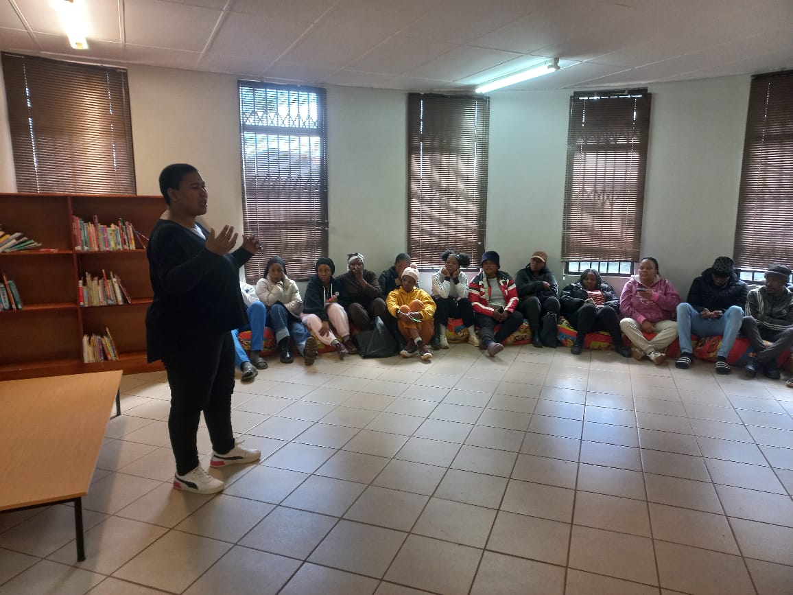 Facilitator speaking to seated young people